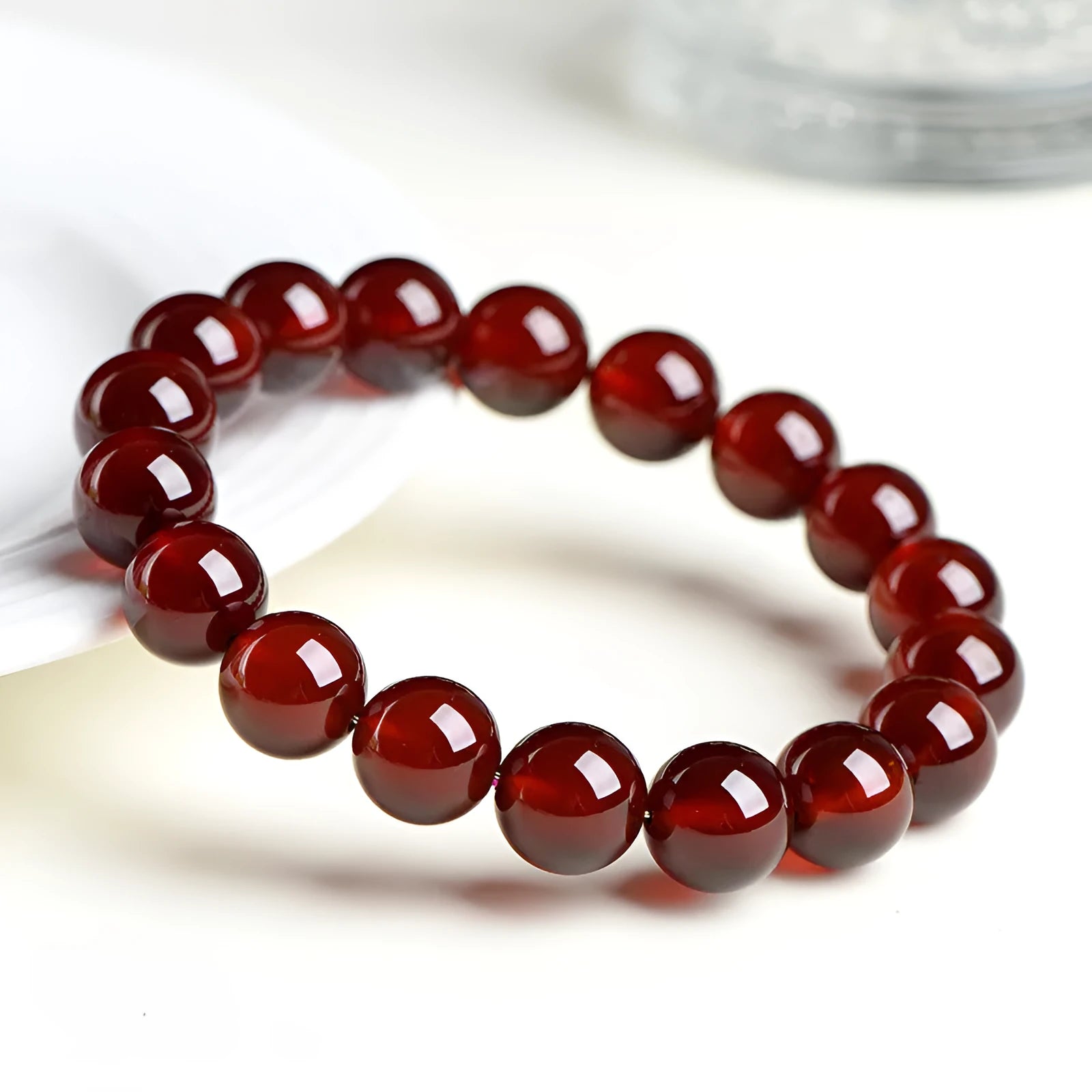 Natural orange red garnet crystal bracelet with Ruyi design elements on wrist