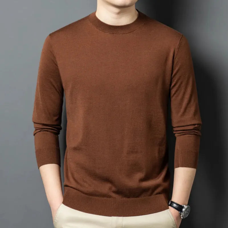 Man wearing a round neck long sleeve wool blend pullover sweater in a neutral colour.