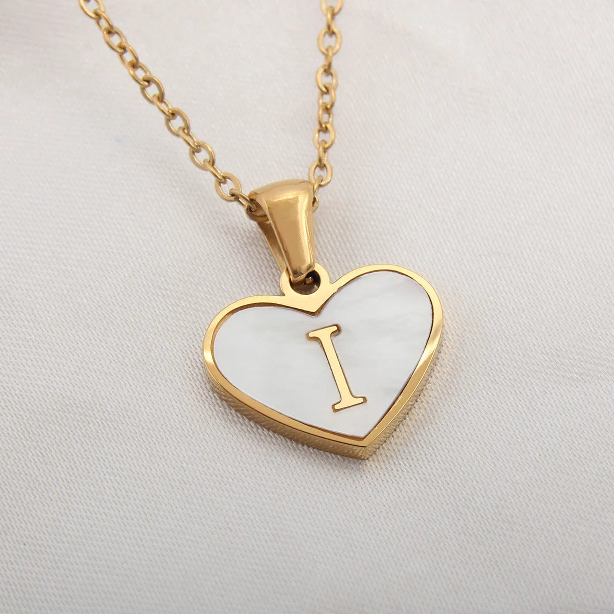 Gold heart necklace with white shell detail and personalised initial letter on adjustable chain