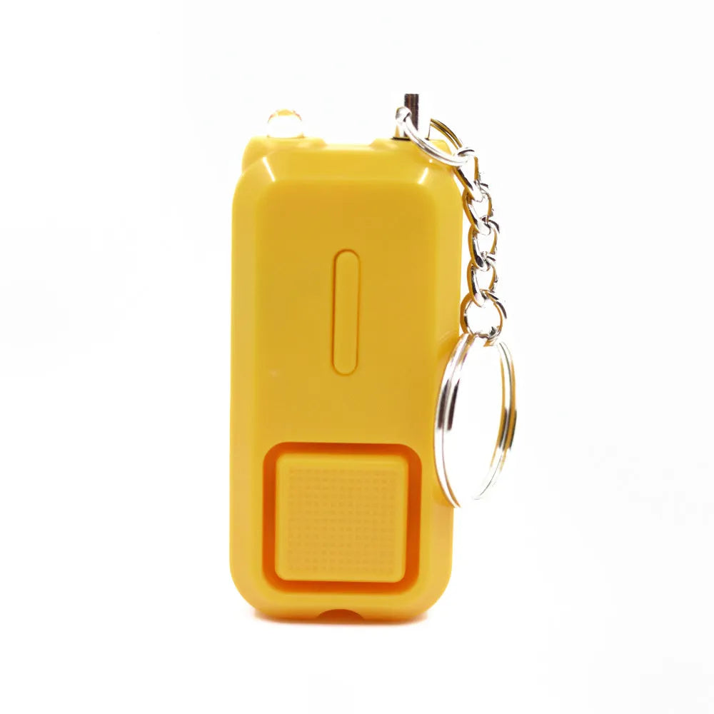 Compact pink personal safety alarm with keyring, showing dimensions next to a ruler.
