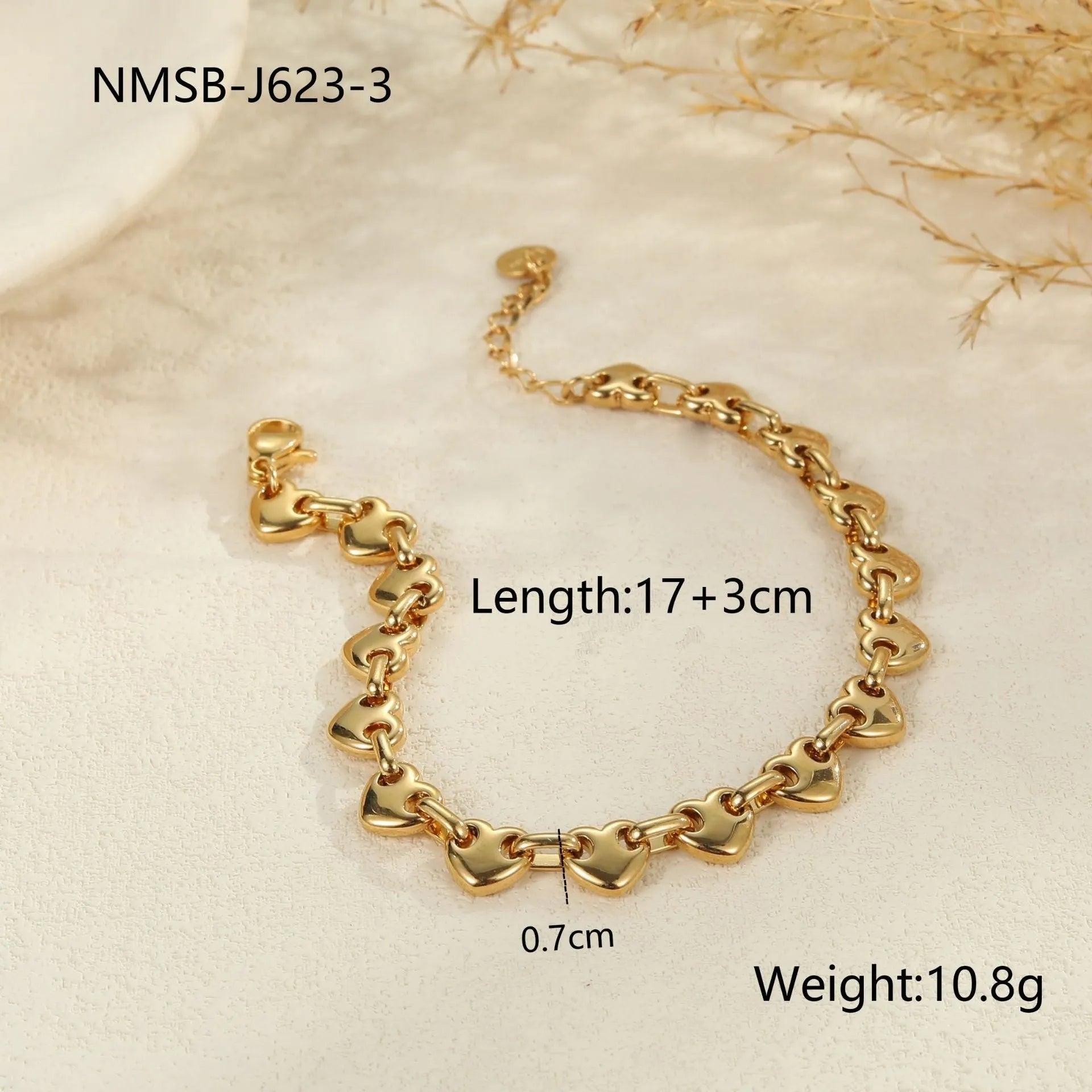 Stainless steel bracelet with a hollowed-out heart charm in a gold electroplated finish.