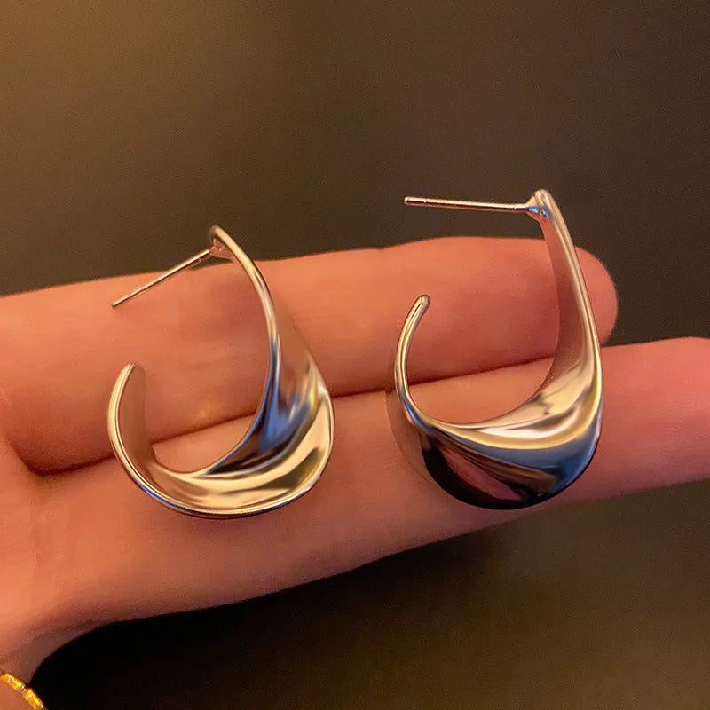 Metal geometric twisted earrings with round elements in gold or silver electroplated finish