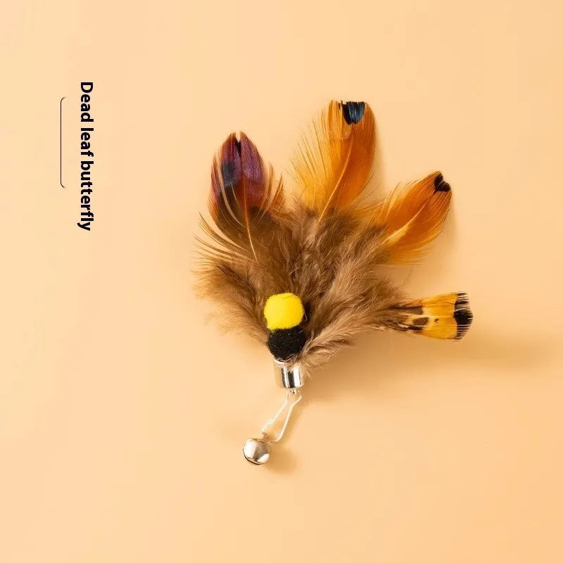Three steel wire cat toys with small coloured flying insect heads on a table.