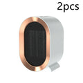 Compact black desktop electric fan heater with mechanical control dials and a safety grille.