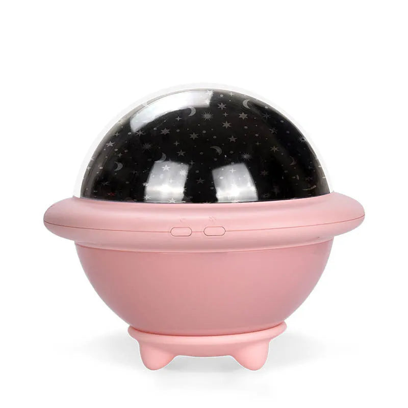 UFO-shaped plastic starry sky projection night light in pink on a wooden surface