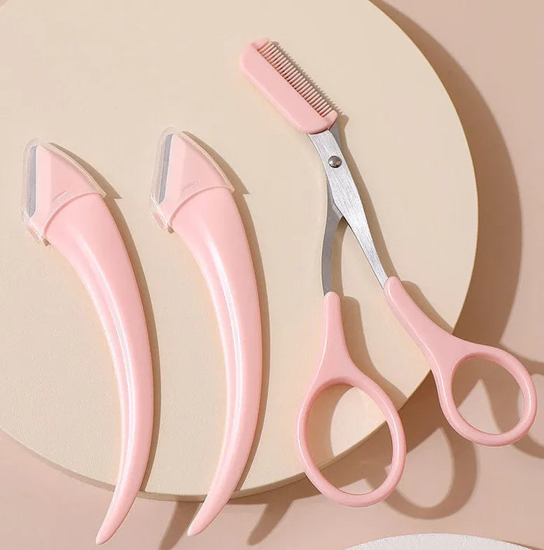 Close-up of a curved moon-shaped eyebrow trimming knife with a comb, in pink and white colours.