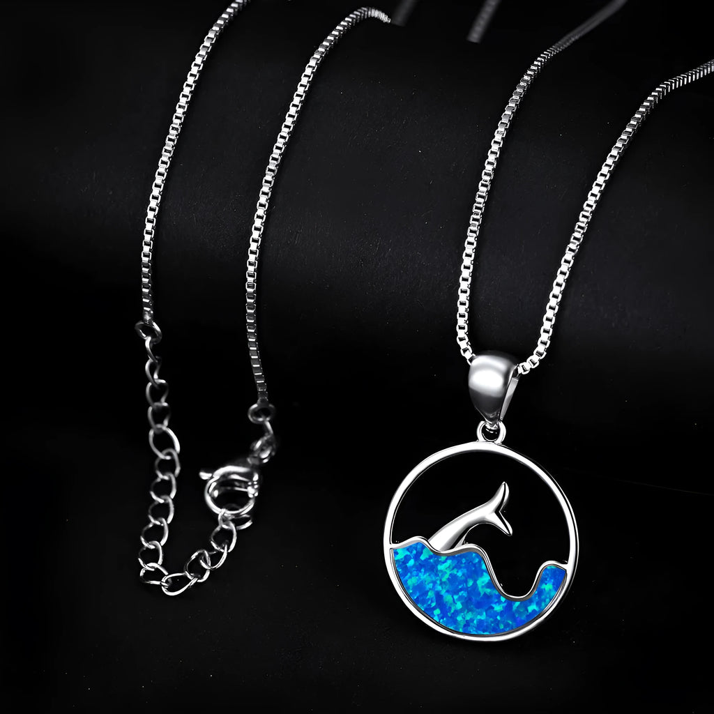 White gold geometric fishtail necklace with a round blue opal pendant on an adjustable chain.