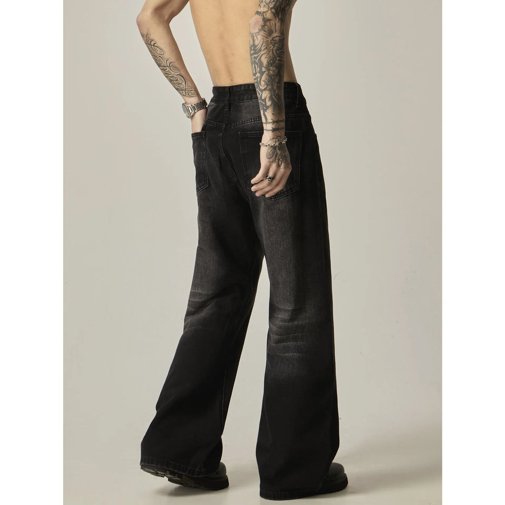 Black loose straight-leg retro jeans on a hanger, showing the front view with zipper fly.