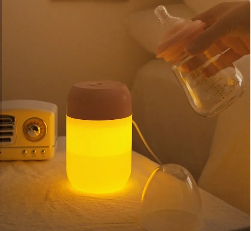 Small white cylindrical USB-powered mini humidifier on a wooden desk.