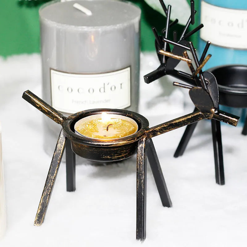 Black iron deer-shaped candlestick holder with fabric decorative elements for Christmas table decoration.