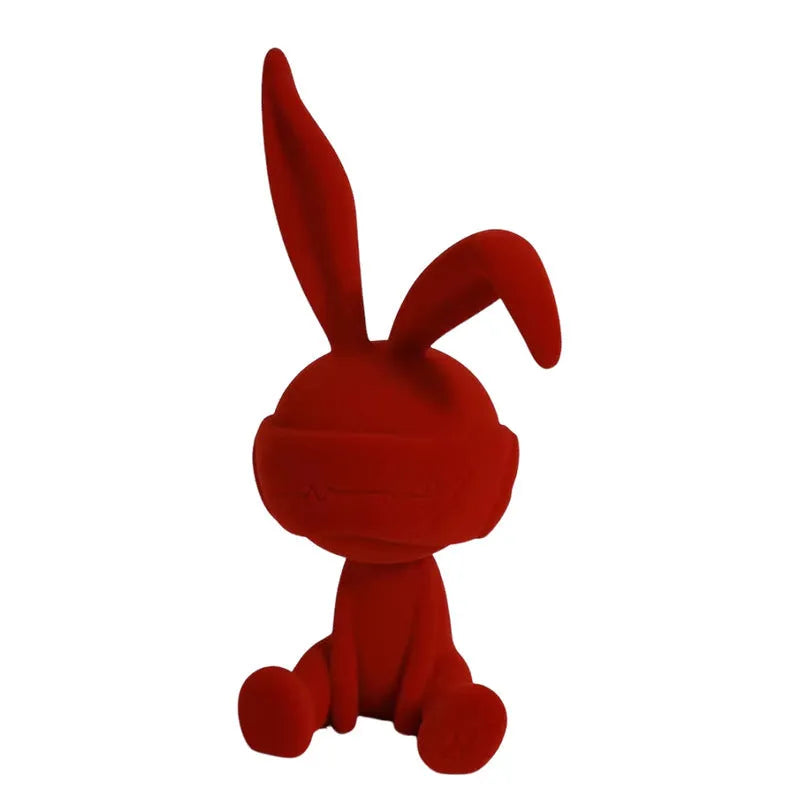 Green resin blindfold rabbit table ornament on a wooden surface.