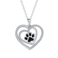 Women's dog paw print necklace with heart-shaped pendant on a cross chain.