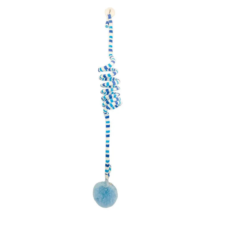 Kitten playing with a spring-mounted hanging ball toy attached to a door by a suction cup.