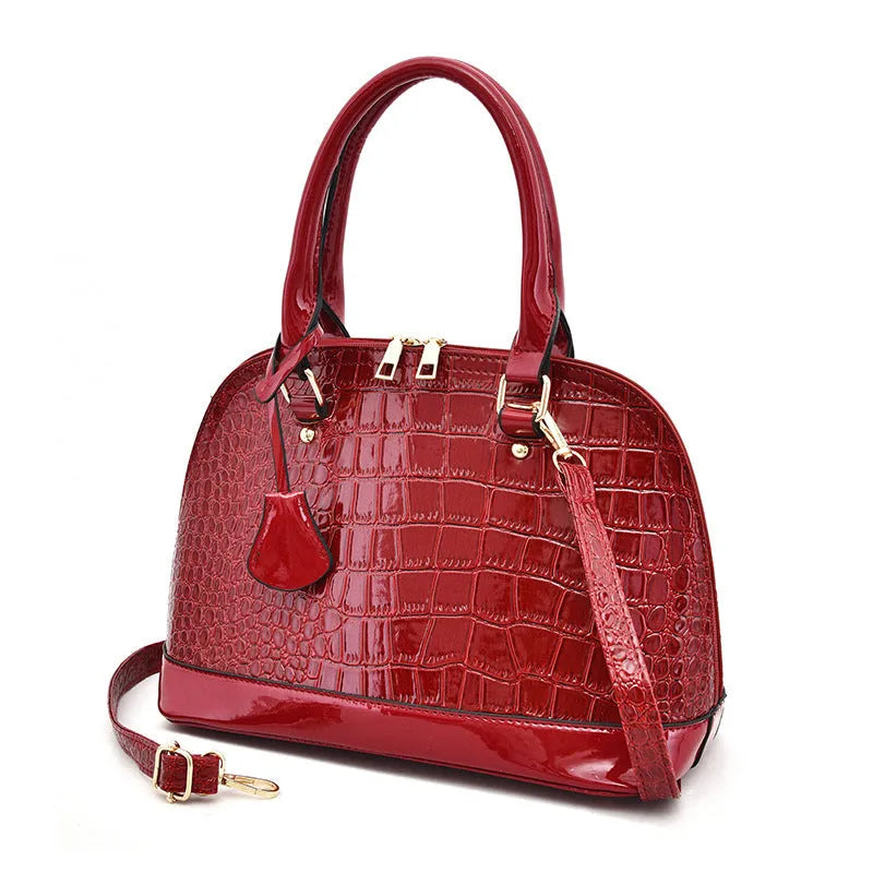 Shiny black PU leather crossbody shoulder bag with a structured shell shape.