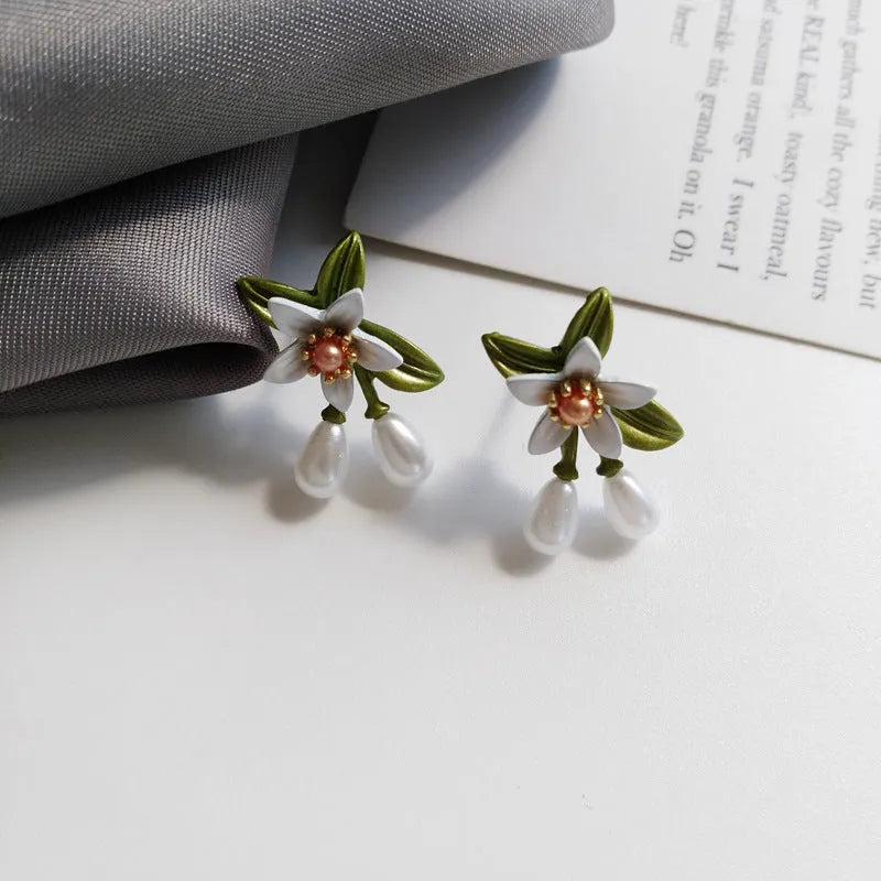 Two pairs of women's floral alloy earrings: one clip-on flower style and one pair of sterling silver needle flower studs.