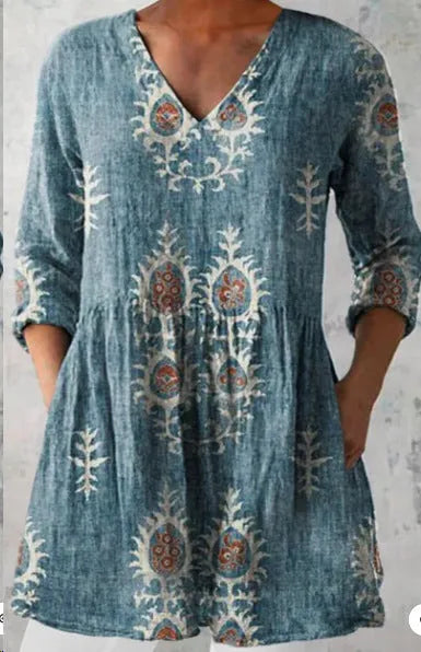 A woman modelling a printed, loose-fitting dress with a wide waist and three-quarter length sleeves.