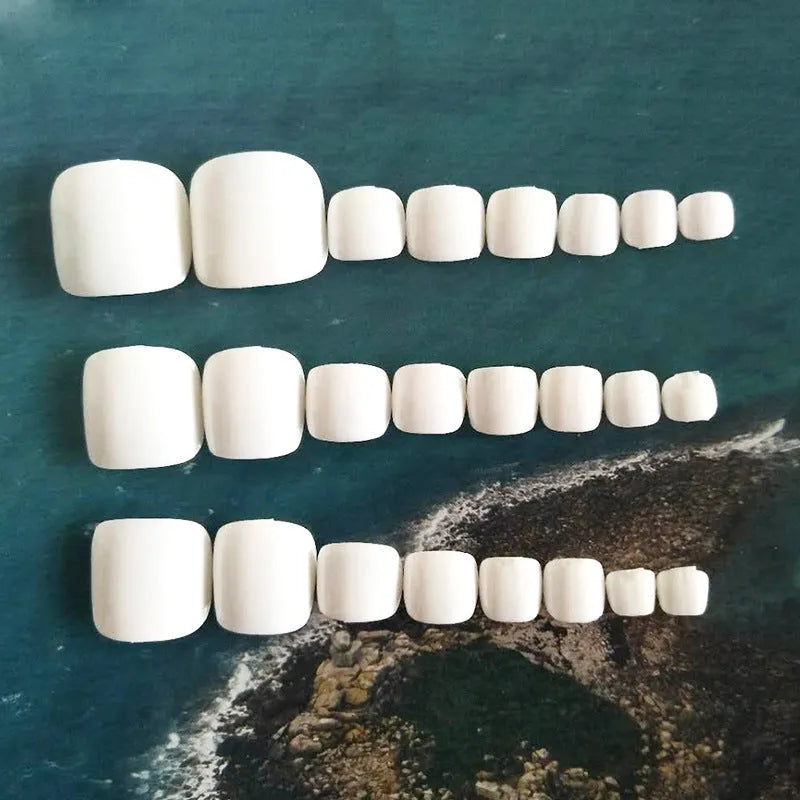 A set of white false nails with a starry sky pattern and glue adhesive.