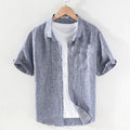 Men's raw jute coloured linen short sleeve shirt with a square collar laid flat.