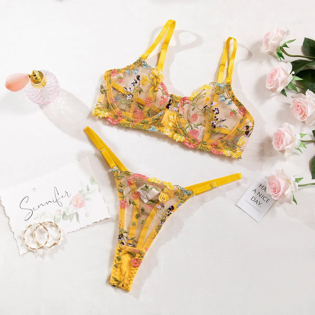 Floral patterned mesh bra with steel ring T-back in various colours on a mannequin.