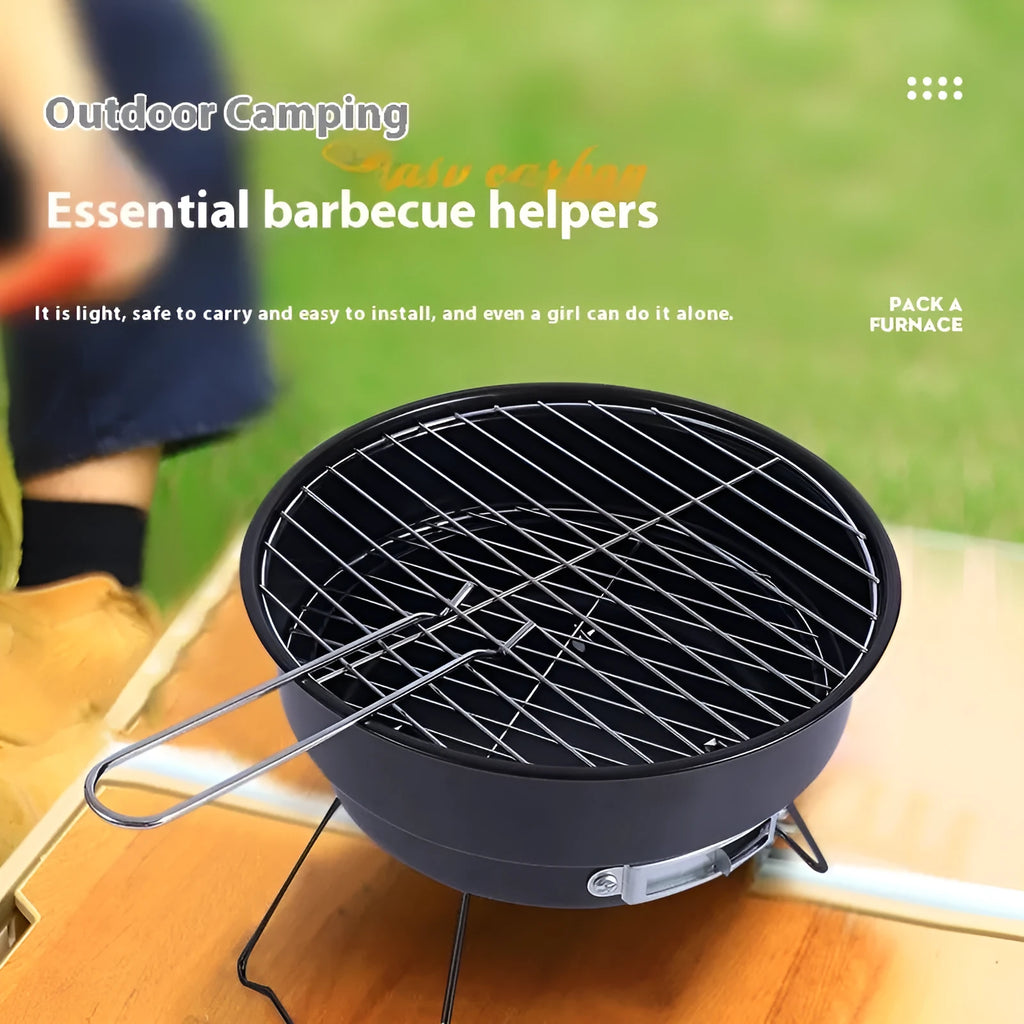 Small metal folding outdoor charcoal stove with mesh grill and tripod legs set up on grass.