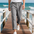 Men's light beige linen casual trousers with drawstring waist and straight-leg fit on a hanger.
