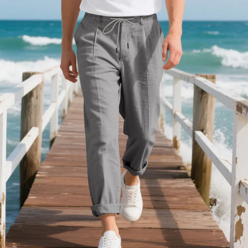 Men's light beige linen casual trousers with drawstring waist and straight-leg fit on a hanger.