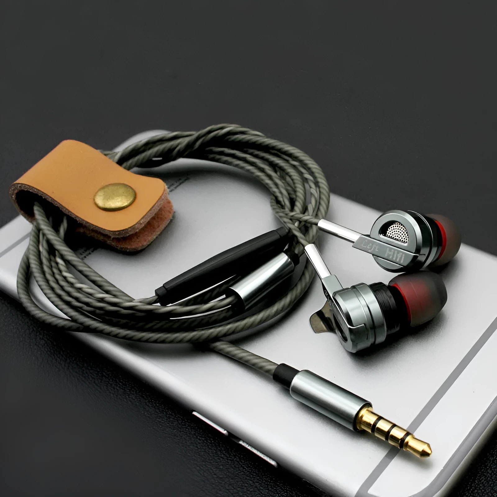 Black and silver metal in-ear headphones with inline remote and microphone on cable.