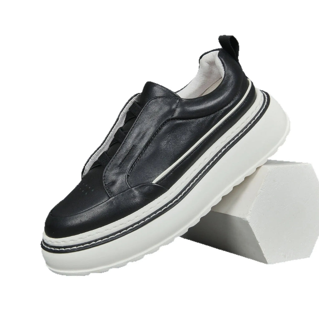 Black leather low-top slip-on sneaker with elastic sides and foam sole on white background