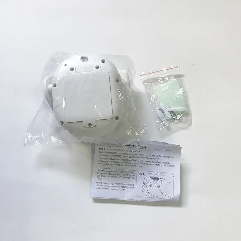 White Atomic Angel induction light unit on a surface showing its compact size.