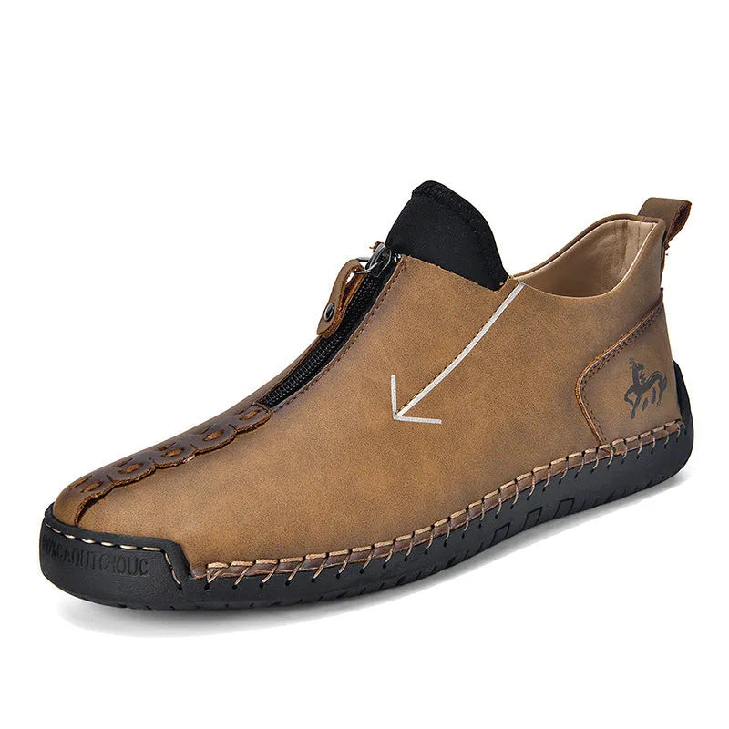 Men's brown leather boots with front zip closure and hand-stitched rubber soles