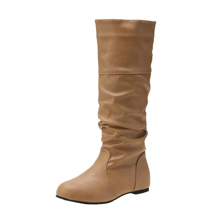 Women's black slip-on long boots with flat heel and round toe on a plain background.