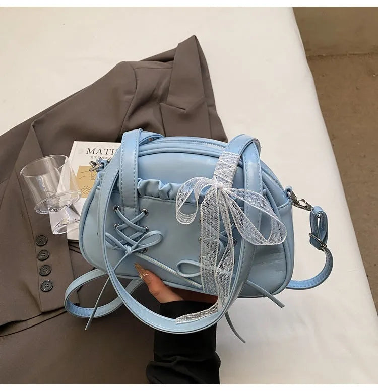 Milky white women's PU leather shoulder bag with a removable bandage bow and visible sewing thread detailing
