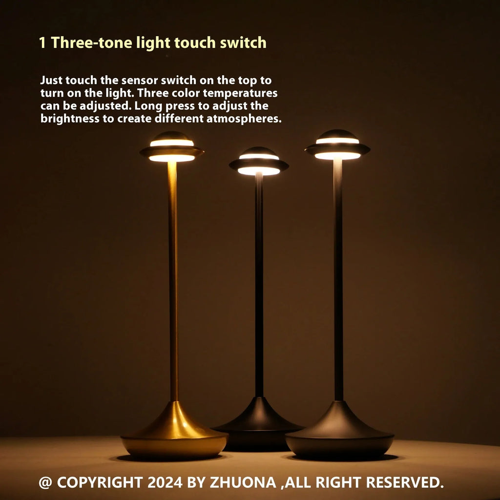Metallic UFO-shaped desk lamp with touch controls in black finish on wooden surface