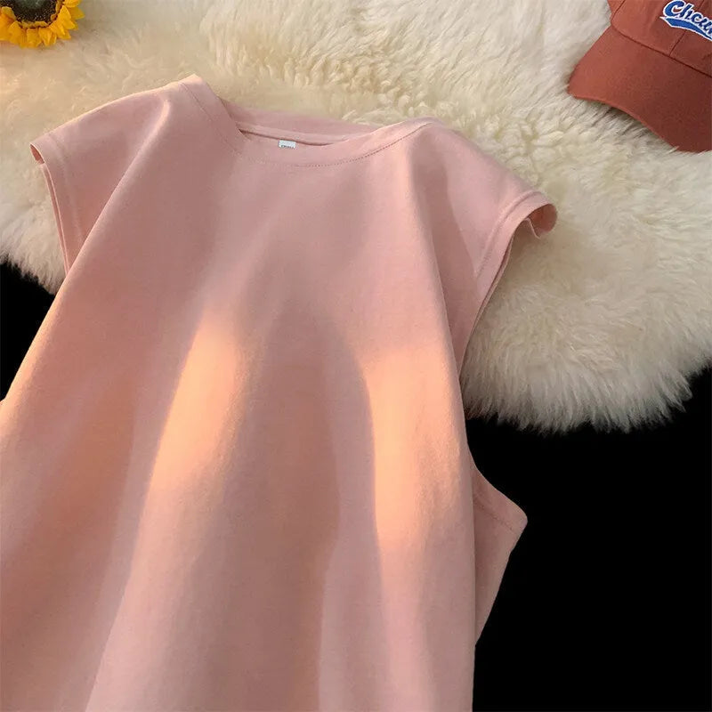 Man wearing a loose, solid-colour cotton sleeveless tank top in a casual setting.