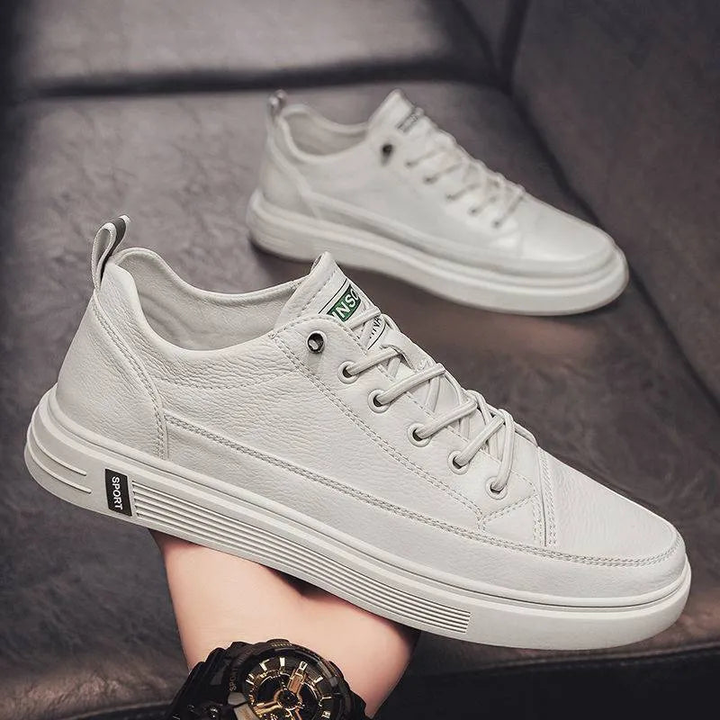 Men's casual white shoes with round toe and flat low-heel sole on a plain background.