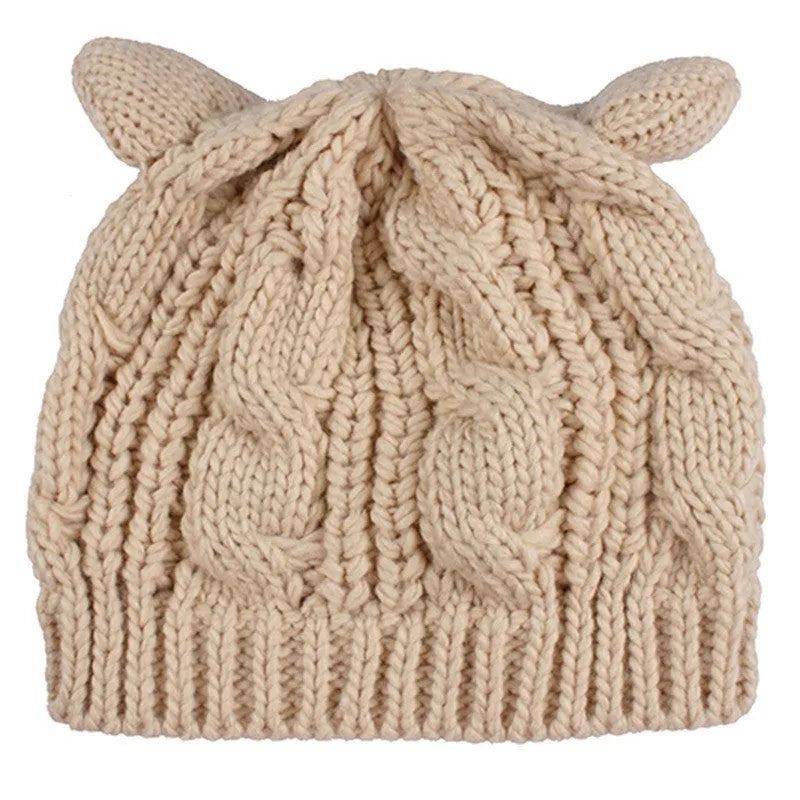 Handmade red knitted beanie with 3D cat ears on a white background