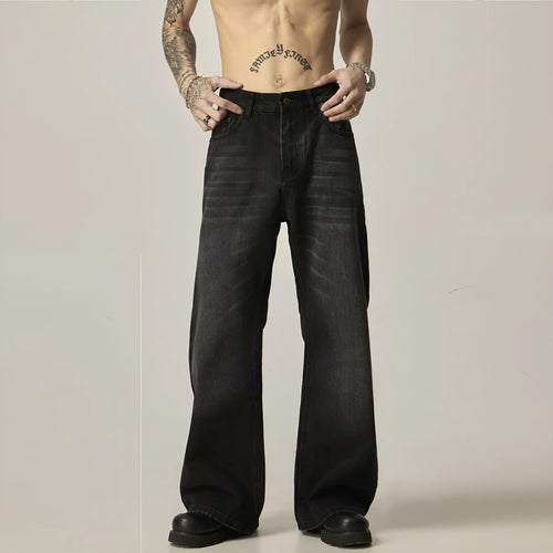 Black loose straight-leg retro jeans on a hanger, showing the front view with zipper fly.