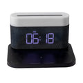 Black wireless charging desk clock with LED display and night light on wooden surface