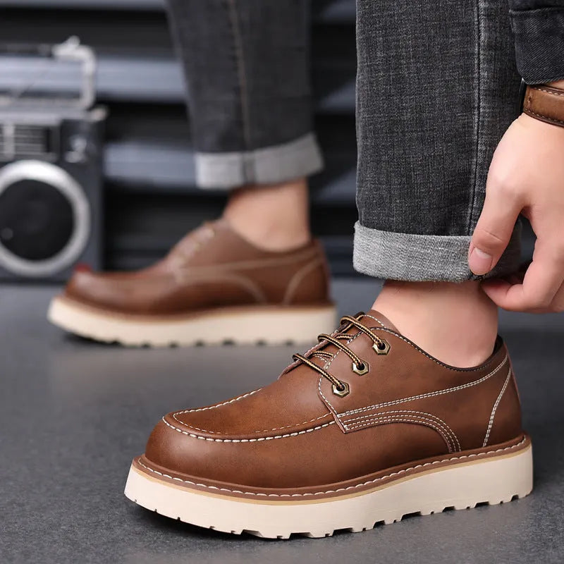 Men's black low-top Martin boots with round toe and rubber sole on a white background.