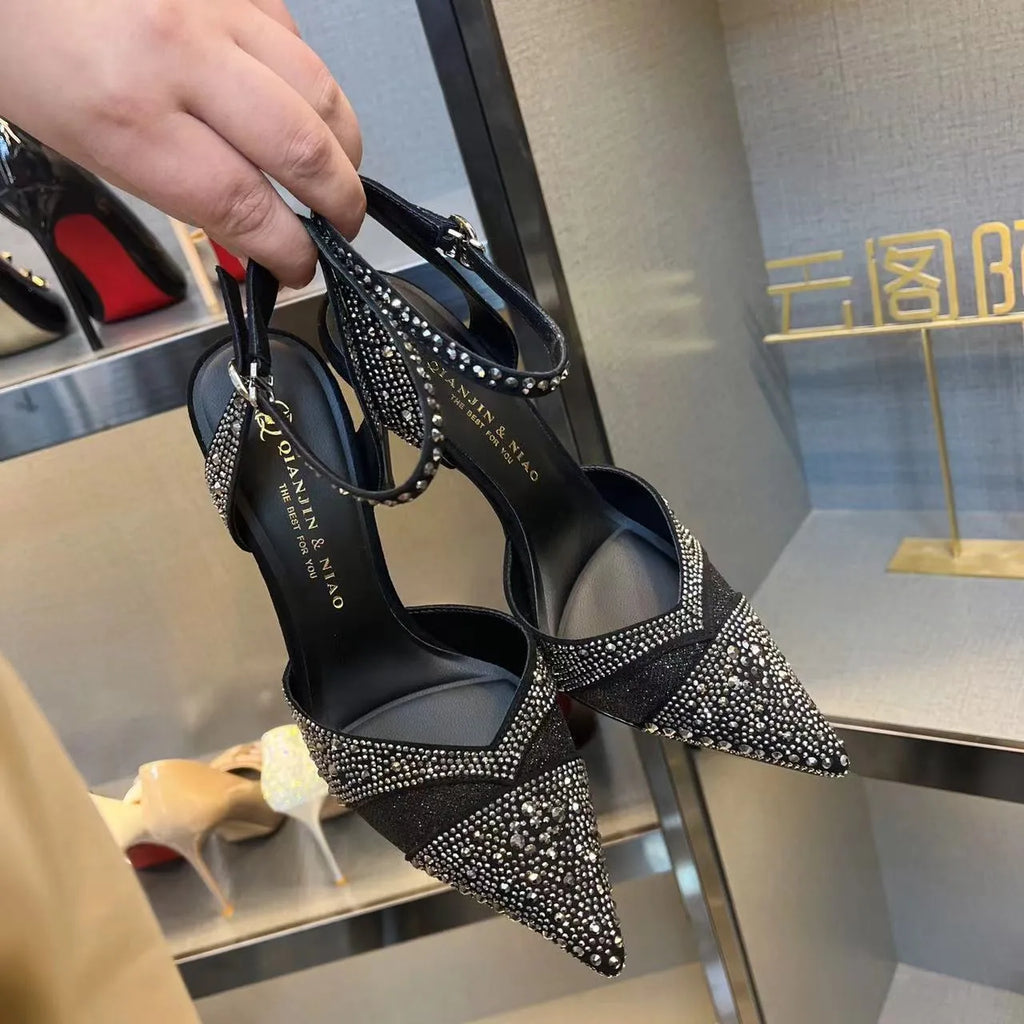 Women's silver high heels with hollow cut-out design and red stiletto heel sole.