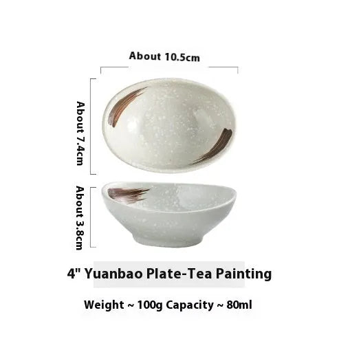 Oval Japanese ceramic dipping bowl with underglaze pattern on a wooden table.