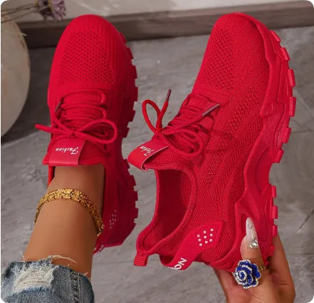 Women's low-top white mesh sports shoes with platform sole and front laces on a grey background.