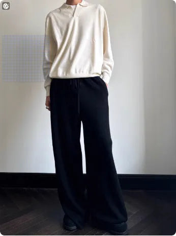 Man wearing a milky white pure wool polo sweater with a lapel collar and loose long sleeves.