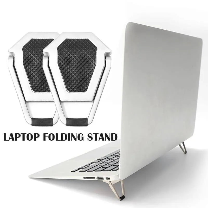 Compact silver aluminium folding laptop stand on a desk next to a wireless keyboard.