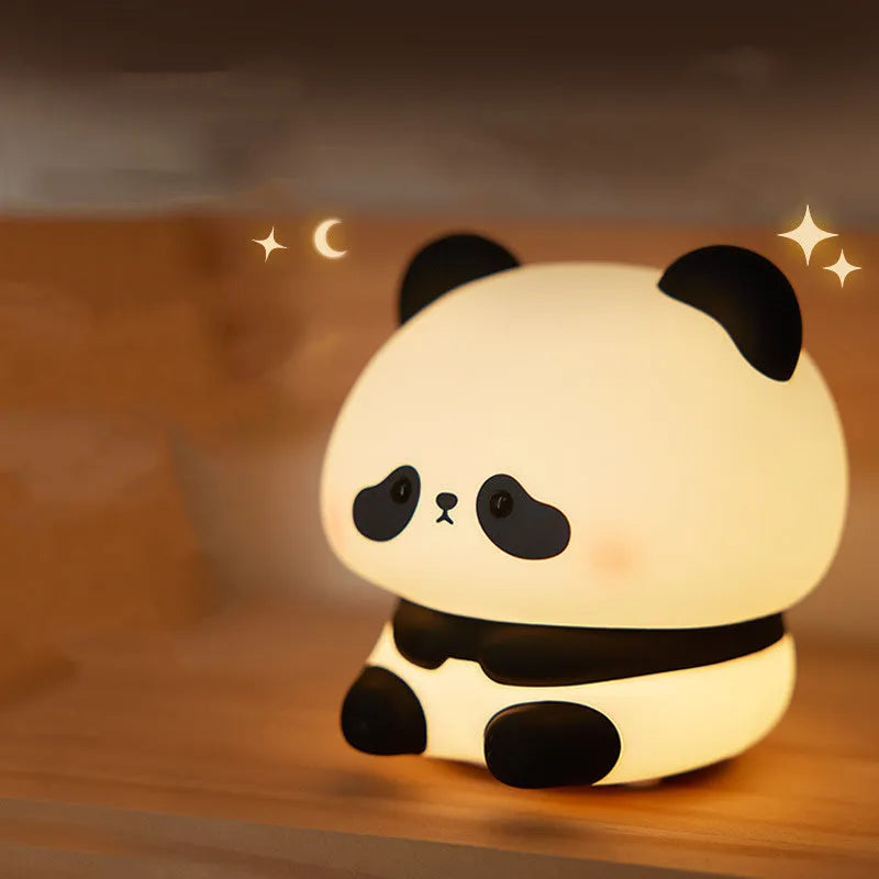Panda shaped silicone night light with warm white glow on dark surface