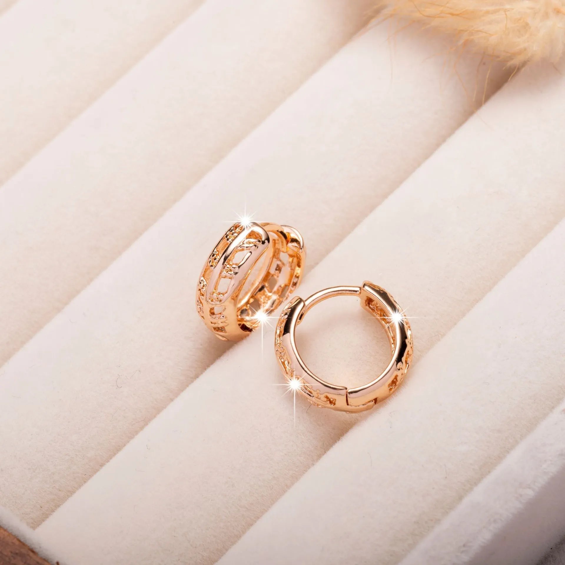 Small rose gold hollowed-out copper earrings with a leaf and a heart pendant design.