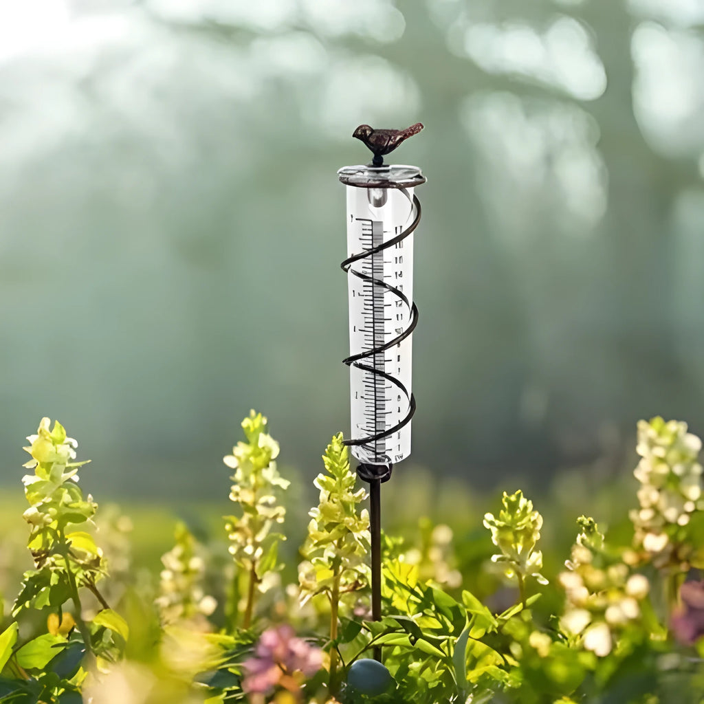 Cast iron and glass outdoor rain gauge with bird design and measurement scale for garden rainfall monitoring