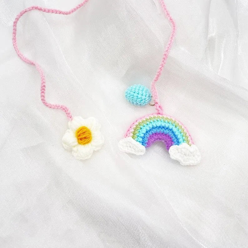 Handmade crocheted avocado-shaped rainbow flower car pendant hanging, shown in multiple colour options.