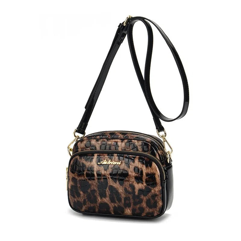 Leopard print crossbody phone bag with PU finish, zip pocket, and 120 cm shoulder strap on neutral background