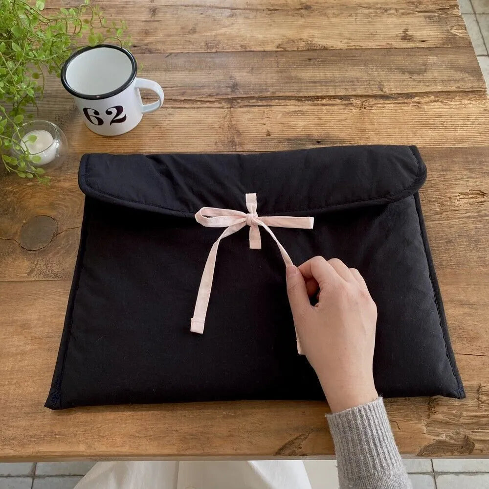 Women's black and white quilted nylon computer bag with ballet bow detailing and striped pattern